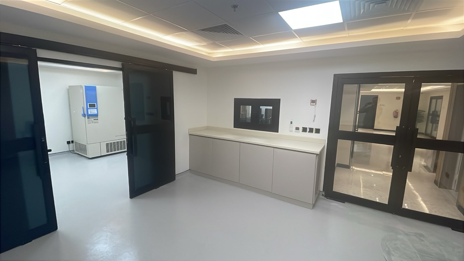 The sample storage room at NAMA Bio-Center, with an ultra-low temperature freezer visible through an open sliding door and a clean preparation counter.